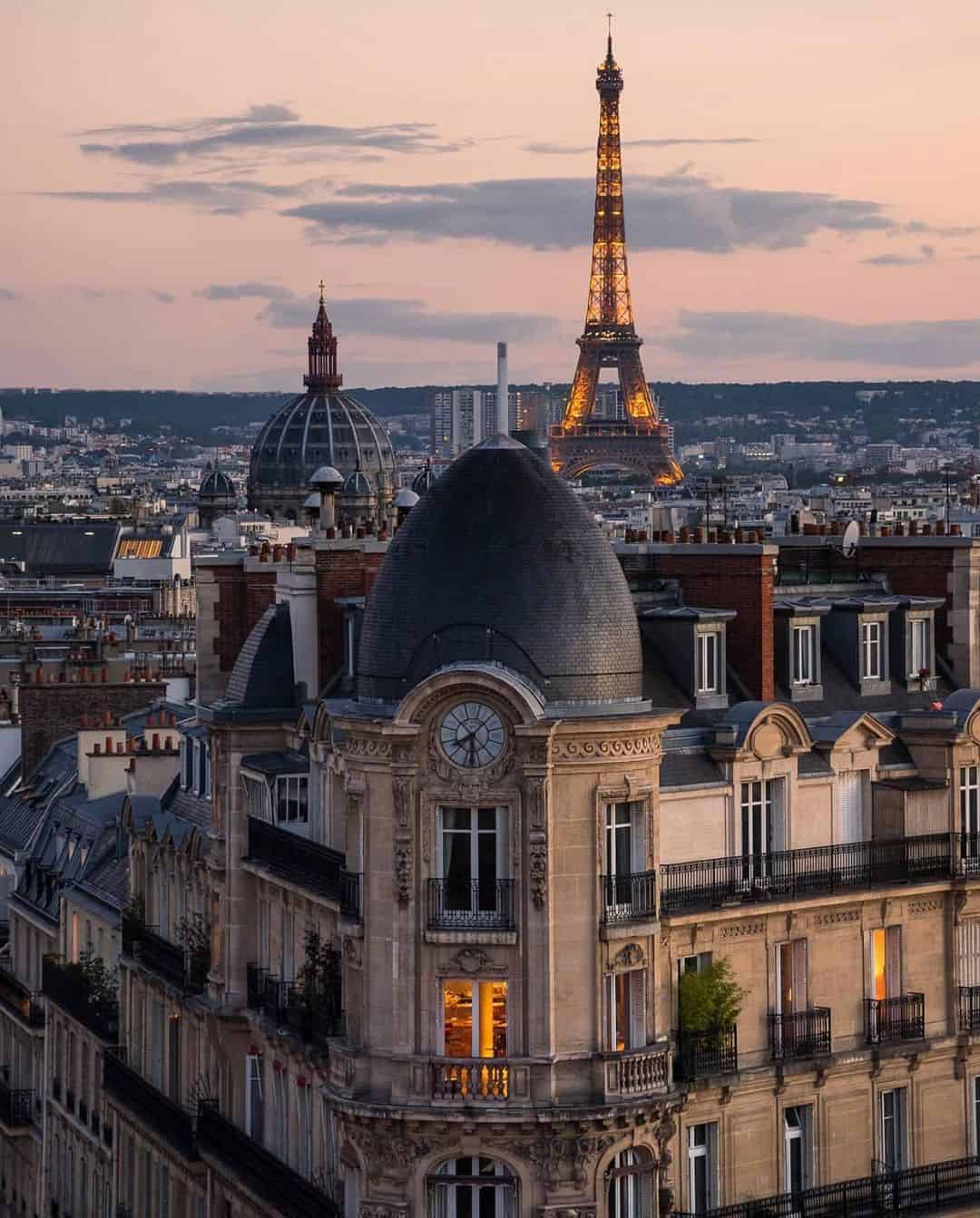 pic of the eiffel tower above the buildings paris travel blog