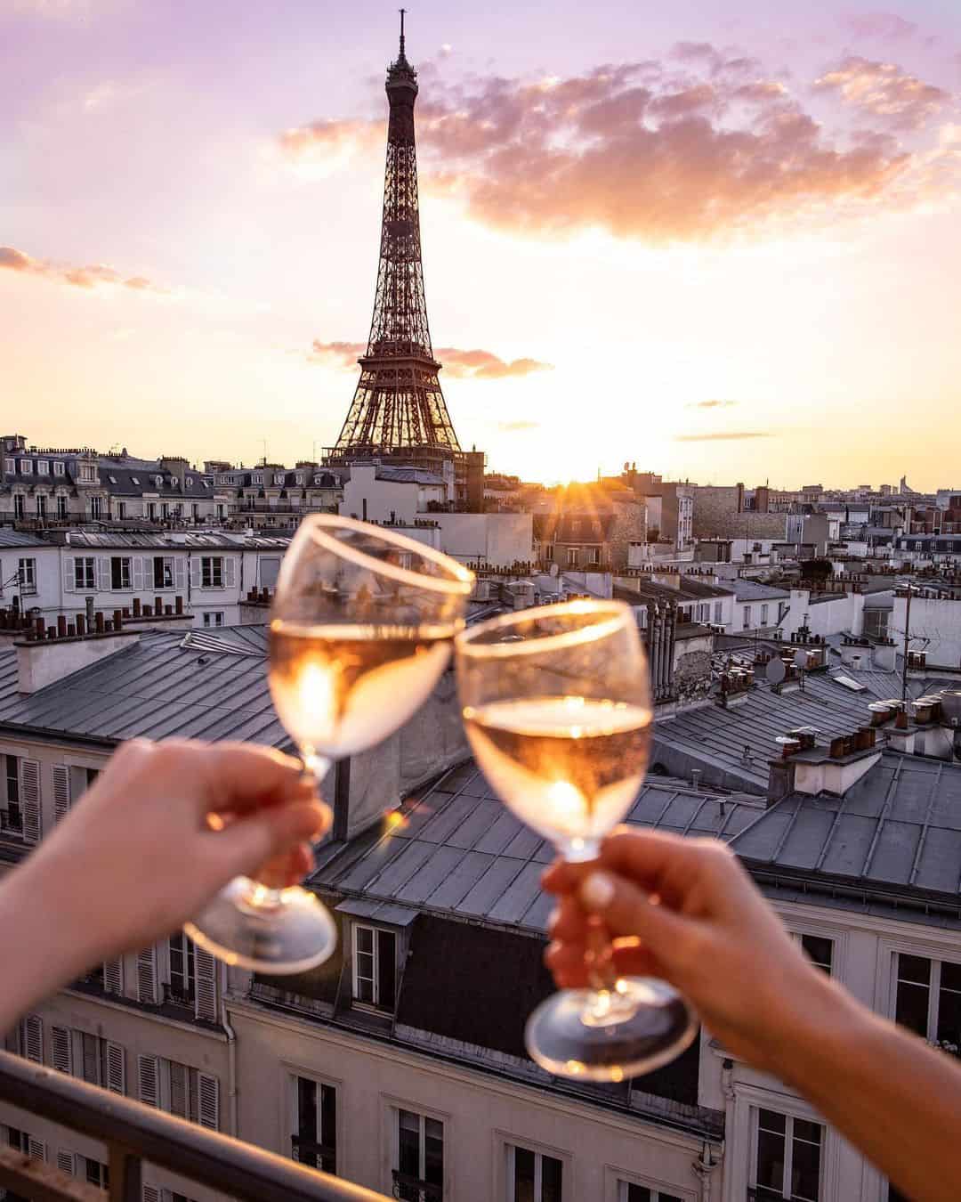 petite in paris cheers in front of the eiffel tower