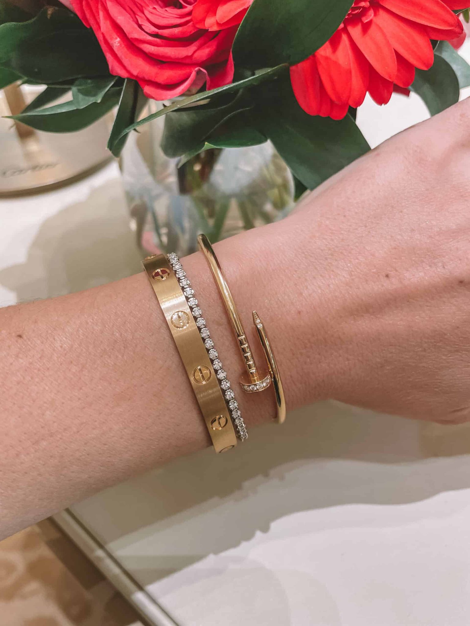 Brushed Gold Cartier Love Bracelet, Diamond Tennis Bracelet, and Juste un Clou bracelet